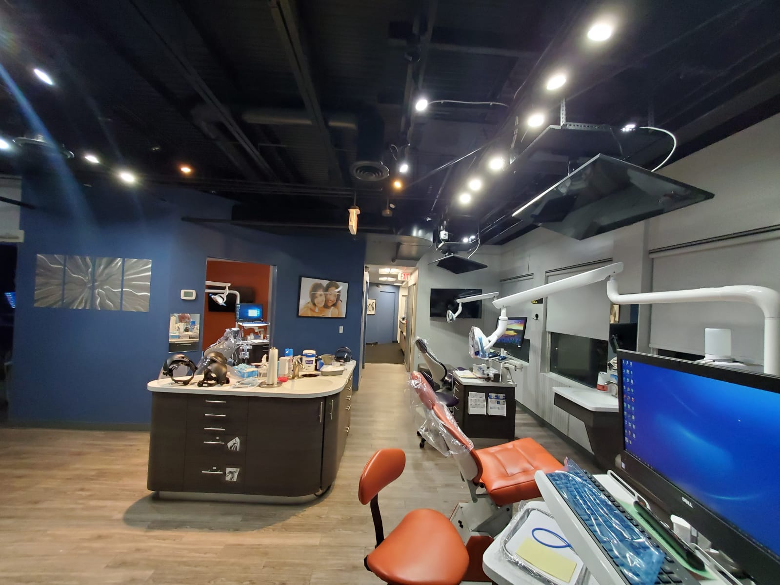 Modern orthodontic treatment bay with digital monitors